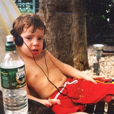 A much younger Jake, poolside in red swim trunks and big headphones